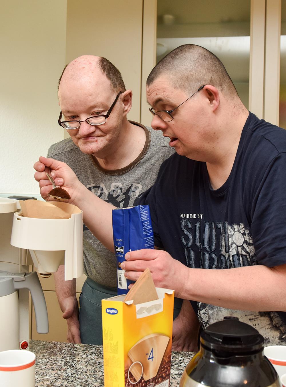 Zwei Männer in Küche mit Kaffeemaschine