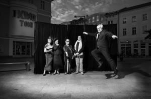 Altes schwarz weiß Foto, Menschen vor einer schwarzen Aufstellwand