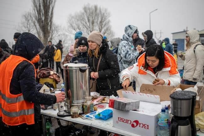 Menschen erhalten heiße Getränke und Essen