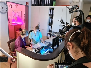 Das Foto zeigt ein Filmteam, das eine Szene an einem Empfangstisch dreht.
