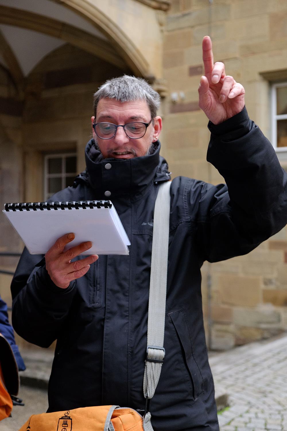 Mann liest ab und hält Vortrag