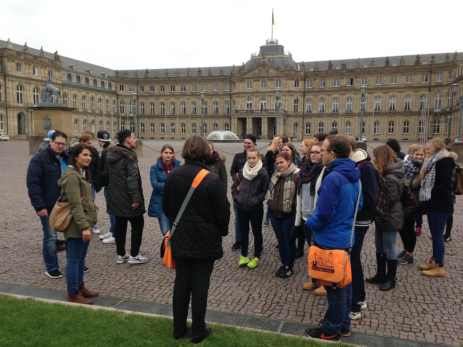 Menschengruppe bei Stadtführung steht auf großem Platz 