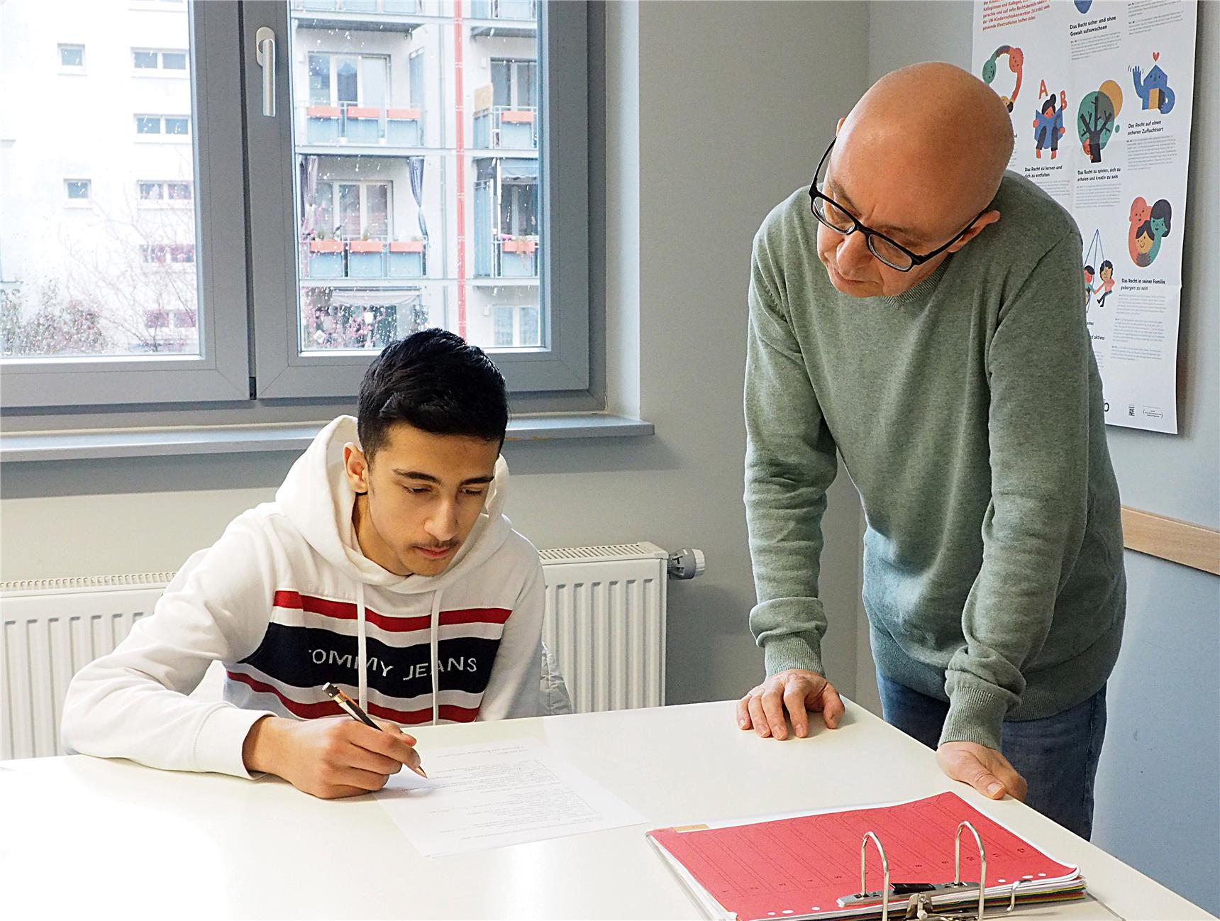 Ein Betreuer lernt mit einem Schüler.