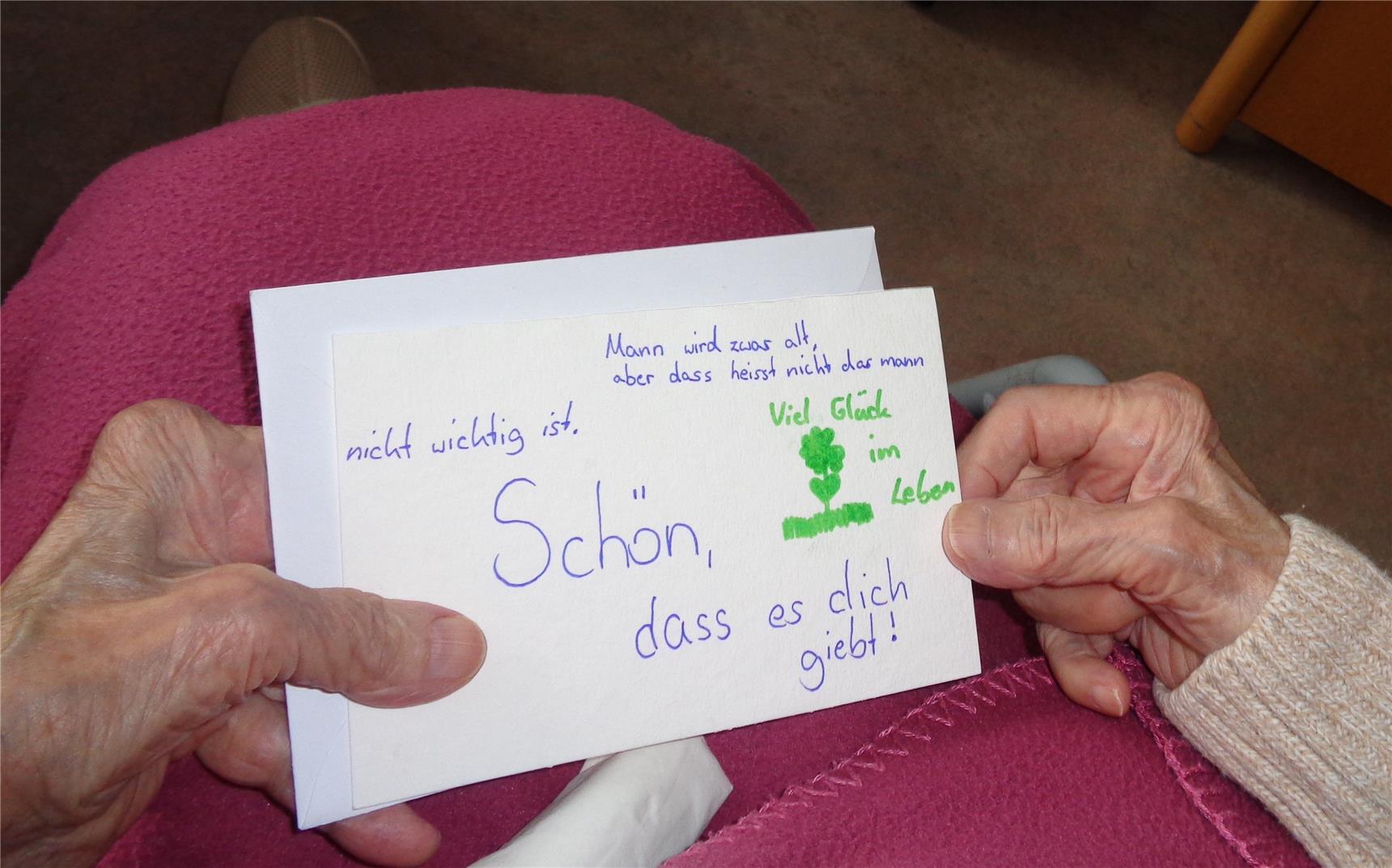 Hände einer alten Frau halten eine Karte der Kinder