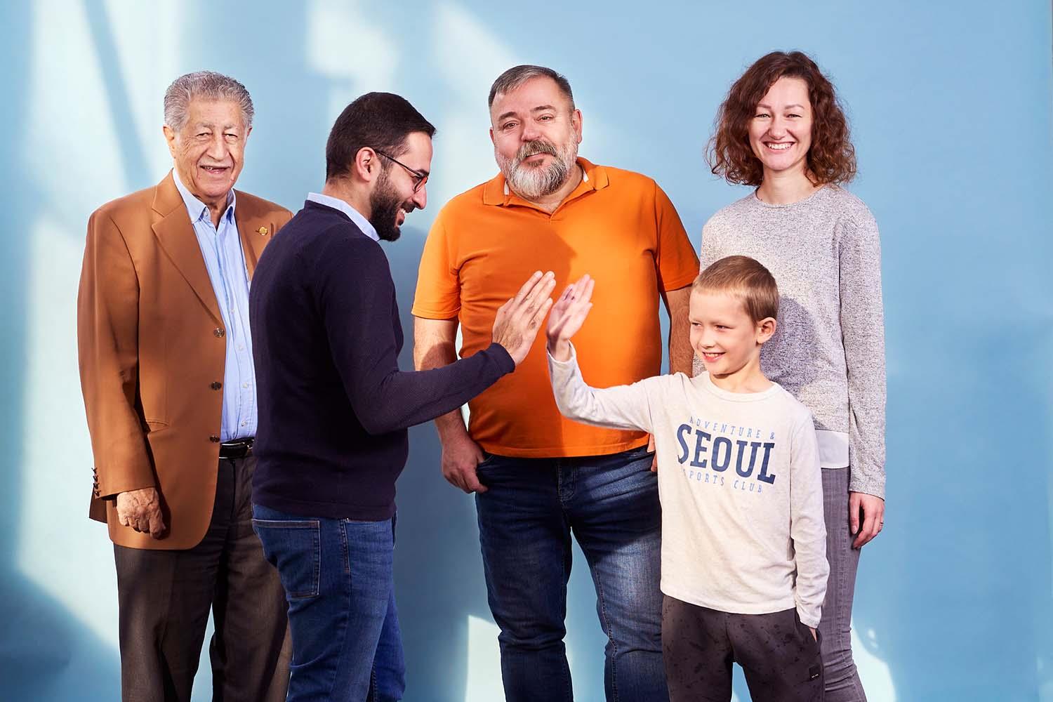 Vier Erwachsene und ein Kind stehen und lachen