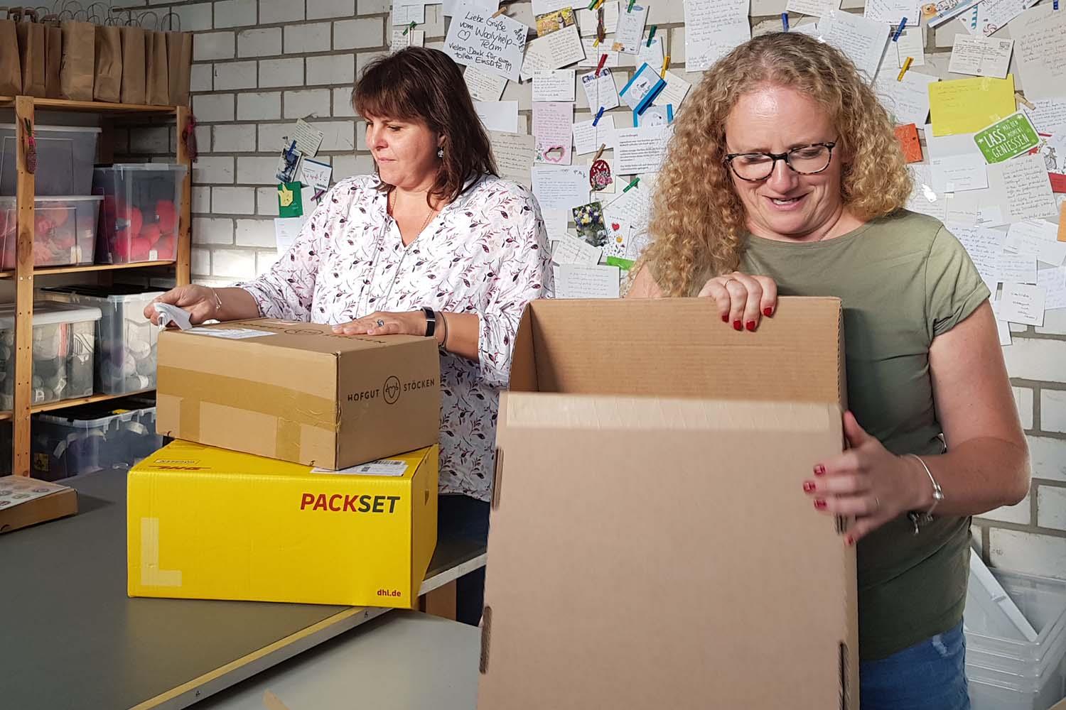 Zwei Freuen packen Pakete. 