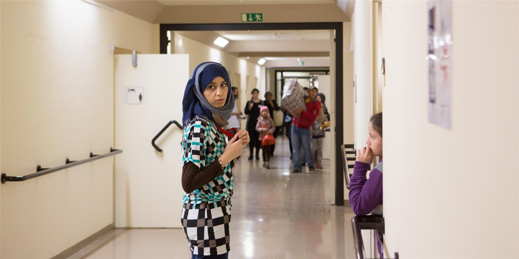 Eine junge Frau in einem langen Gang der Notunterkunft