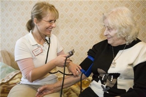 Eine alte Frau wird von einer Pflegefachkraft gepflegt